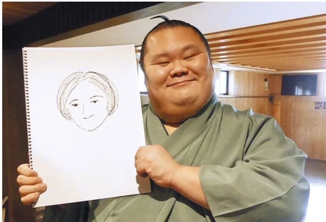 奥様の似顔絵を持ち微笑む千代丸